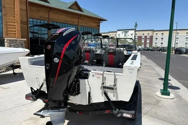 Slide: The Image of 2026 Ranger VX1988 WT boat with powerful outboard motor, parked near modern buildings. - 2