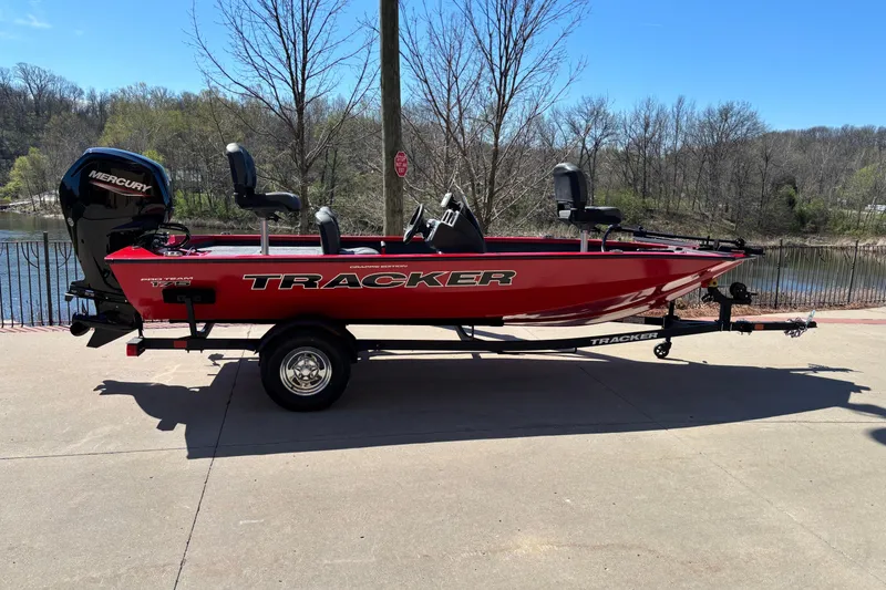 The Image of 2026 Tracker Pro Team 175 Crappie Edition boat, red, parked near a scenic lake. - 0