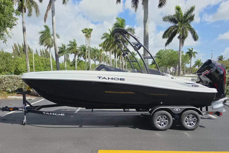 The Image of 2026 Tahoe T21 boat on trailer, parked with palm trees in the background. - 0