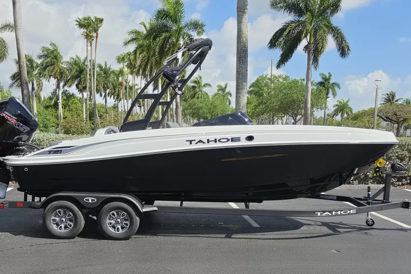 Slide: The Image of 2026 Tahoe T21 boat on trailer, parked with palm trees in the background. - 1