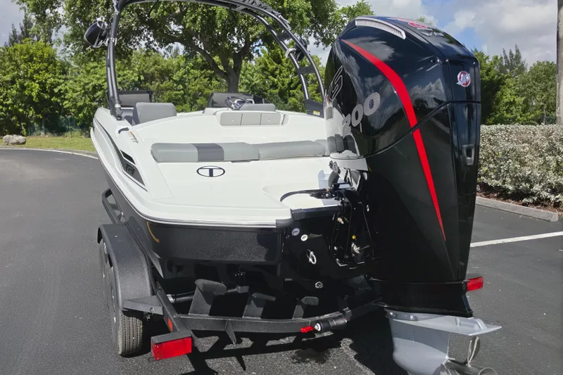 Slide: The Image of 2026 Tahoe T21 boat with powerful outboard motor on a trailer, parked outdoors. - 10