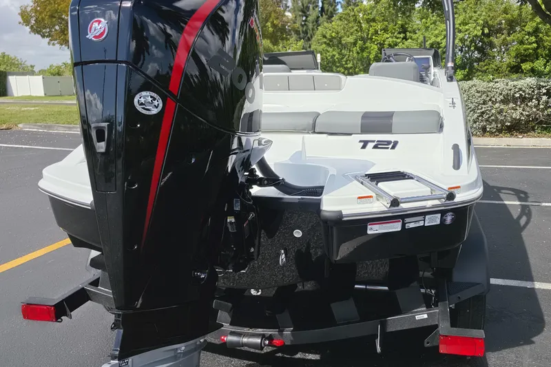 Slide: The Image of 2026 Tahoe T21 boat with powerful outboard motor, parked on asphalt, surrounded by greenery. - 11