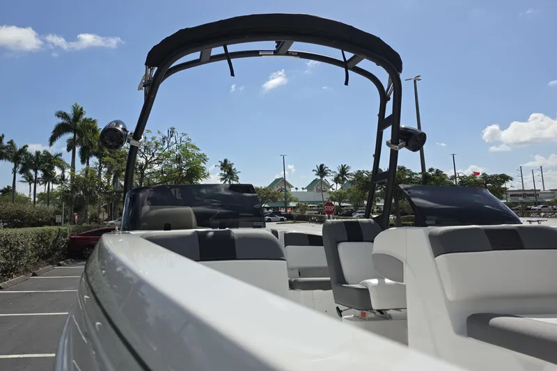 Slide: The Image of 2026 Tahoe T21 boat with seating, parked under a clear blue sky. - 2
