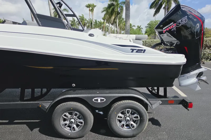 Slide: The Image of 2026 Tahoe T21 boat on trailer with Mercury Pro XS engine, parked outdoors. - 9