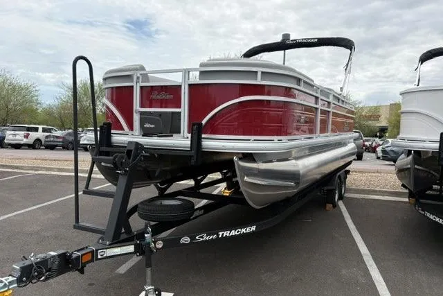 Slide: The Image of 2026 Sun Tracker SportFish 22 DLX pontoon boat on trailer in parking lot. - 1