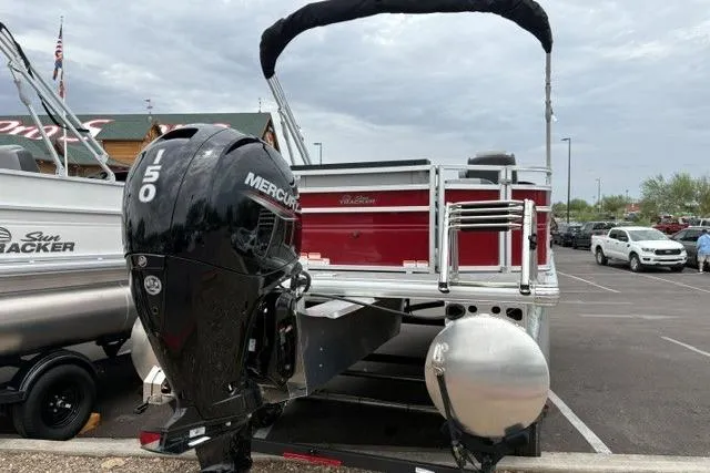 Slide: The Image of 2026 Sun Tracker SportFish 22 DLX pontoon boat with Mercury 150 engine in parking lot. - 2
