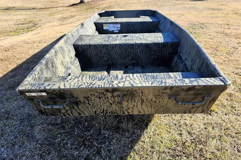 Slide: The Image of 2026 Tracker Grizzly 15 Jon boat with camouflage pattern on grassy terrain. - 3