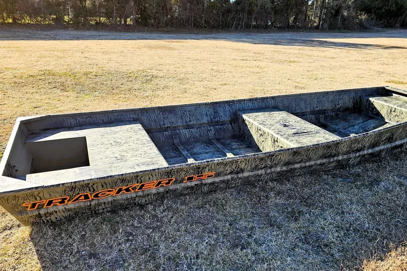 Slide: The Image of 2026 Tracker Grizzly 15 Jon boat on grassy field, showcasing rugged design. - 4