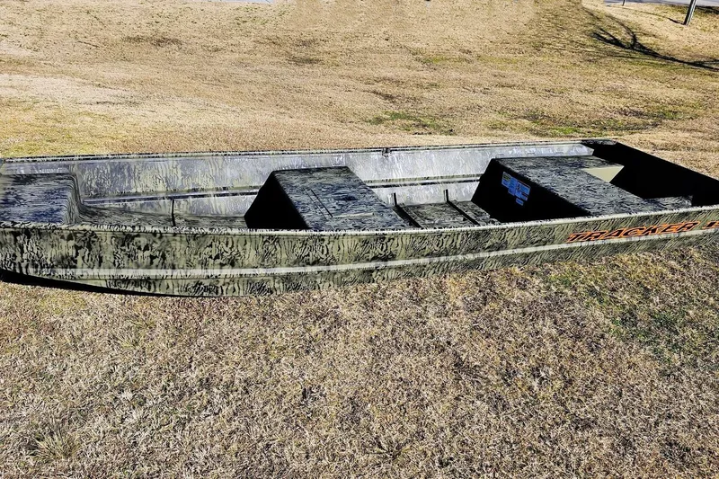 Slide: The Image of 2026 Tracker Grizzly 15 Jon boat on grassy terrain, showcasing rugged design. - 5