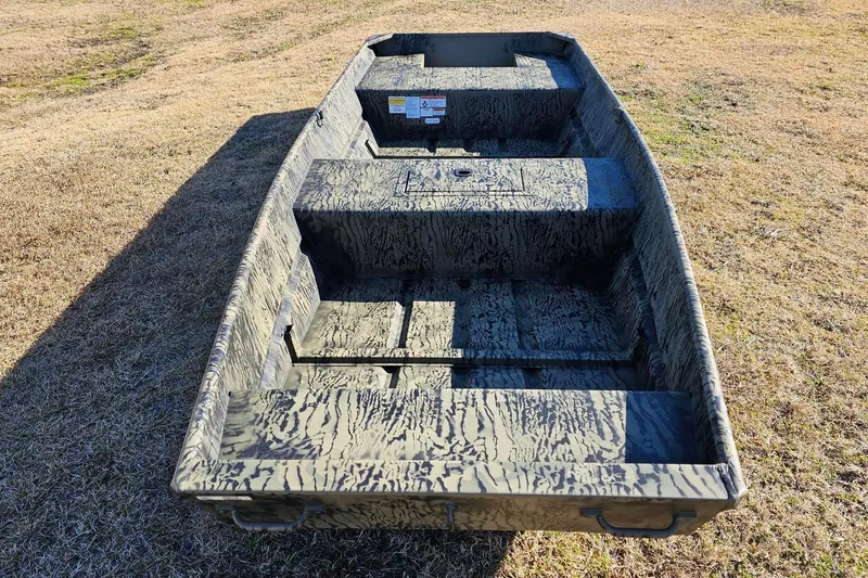 Slide: The Image of 2026 Tracker Grizzly 15 Jon boat on grassy terrain, showcasing interior design. - 6