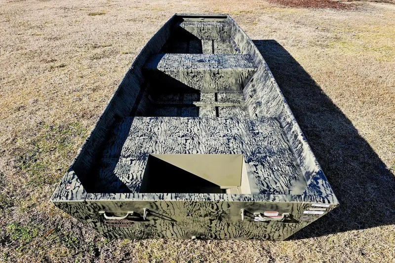 Slide: The Image of 2026 Tracker Grizzly 15 Jon boat with camouflage design on grassy terrain. - 7