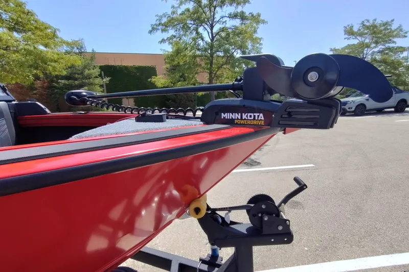 Slide: The Image of Red 2026 Tracker Targa V-18 Combo boat with Minn Kota PowerDrive motor in parking lot. - 5