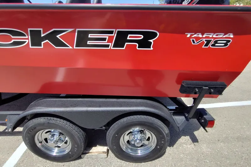 Slide: The Image of 2026 Tracker Targa V-18 Combo boat on trailer, red exterior, dual wheels. - 4