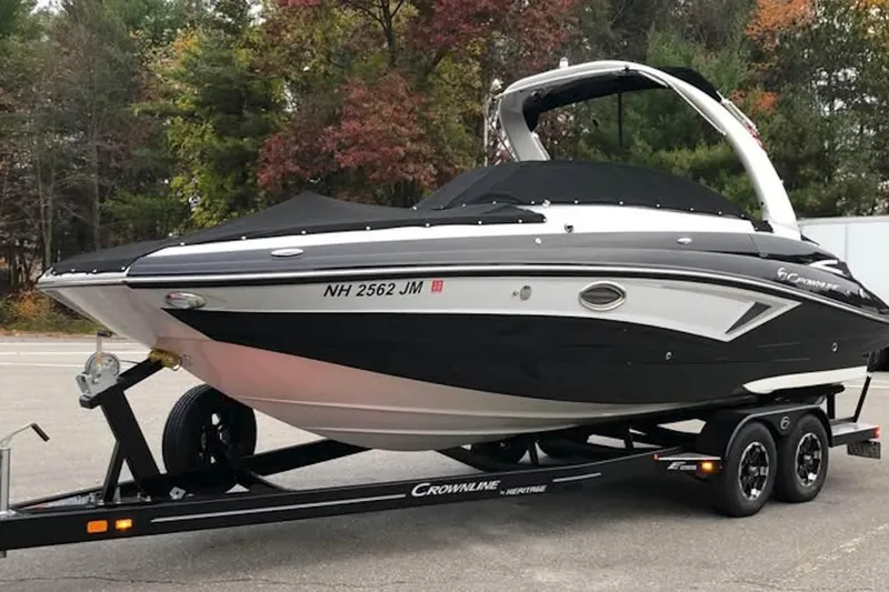 The Image of 2020 Crownline Eclipse E255 boat on trailer, surrounded by autumn trees. - 1