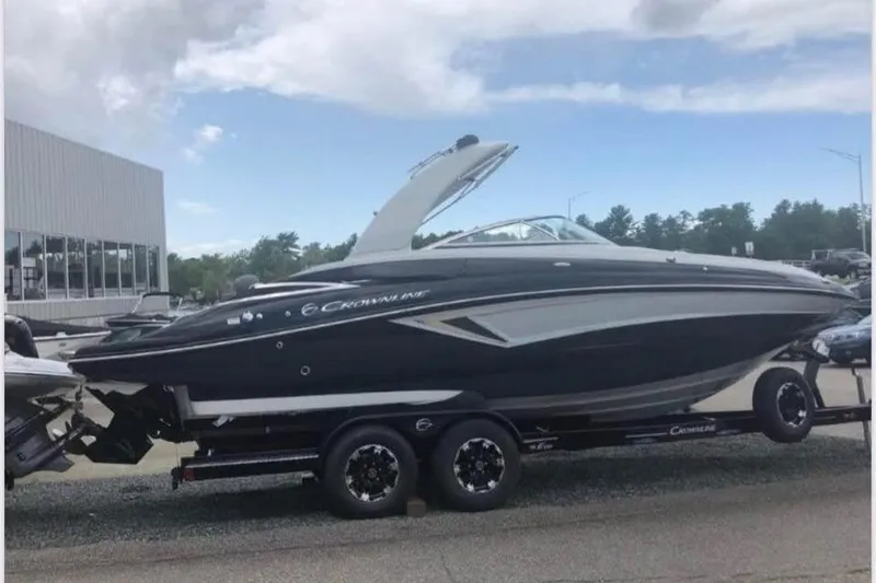 Slide: The Image of 2020 Crownline Eclipse E255 boat on trailer, parked outdoors under cloudy sky. - 4