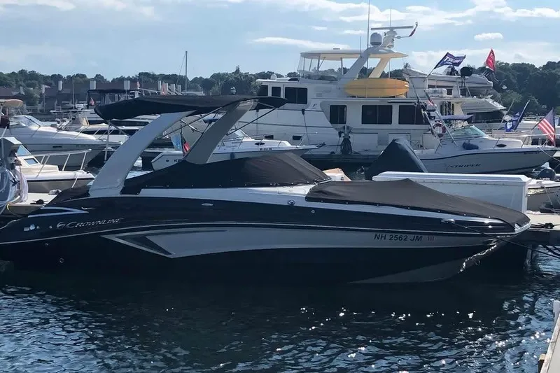 Slide: The Image of 2020 Crownline Eclipse E255 boat docked in a marina, surrounded by other vessels. - 5