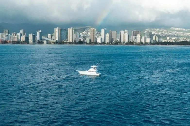 Slide: The Image of Boat on ocean with city skyline and rainbow in background, Post 50 model, 1998. - 26