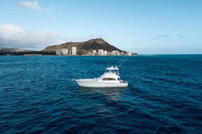 Slide: The Image of A 1998 Post 50 yacht on blue ocean with mountain and city skyline. - 27