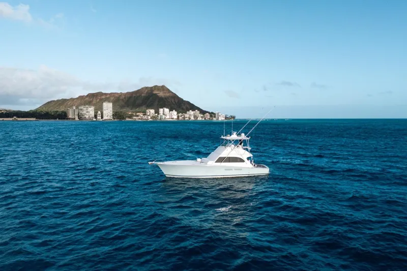 Slide: The Image of A 1998 Post 50 yacht cruising on blue ocean near a coastal cityscape. - 28