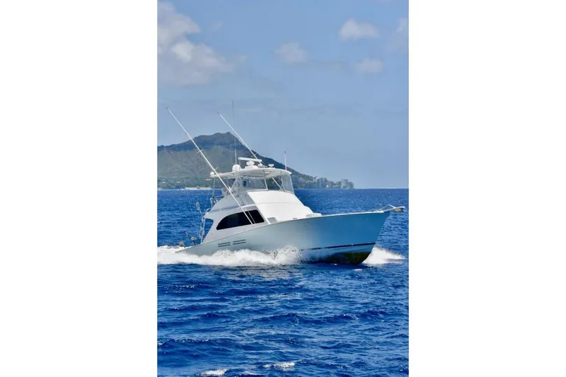 Slide: The Image of 1998 Post 50 yacht cruising on blue ocean with scenic mountain backdrop. - 4