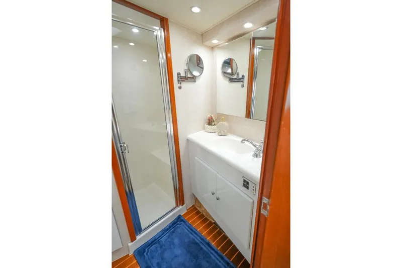 Slide: The Image of Compact yacht bathroom with shower, vanity, and blue rug in 1998 Post 50 model. - 8