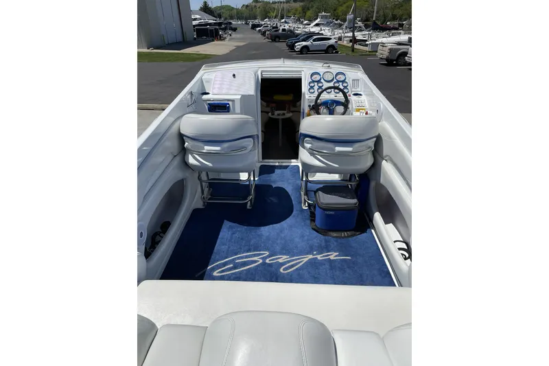 Slide: The Image of 2000 Baja 33 Outlaw boat interior with blue carpet and white seating. - 2