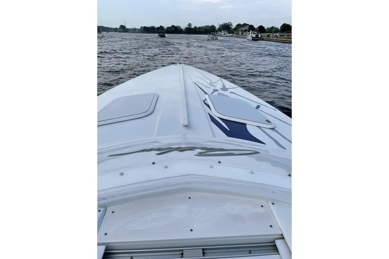 Slide: The Image of 2000 Baja 33 Outlaw boat cruising on a calm river. - 8