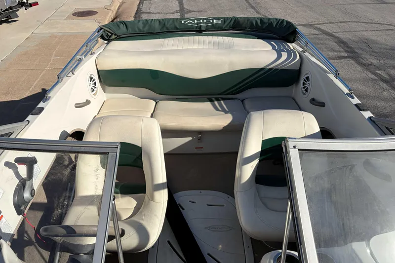 Slide: The Image of 2007 Tahoe Q4 boat interior with seating and steering wheel, parked on pavement. - 4