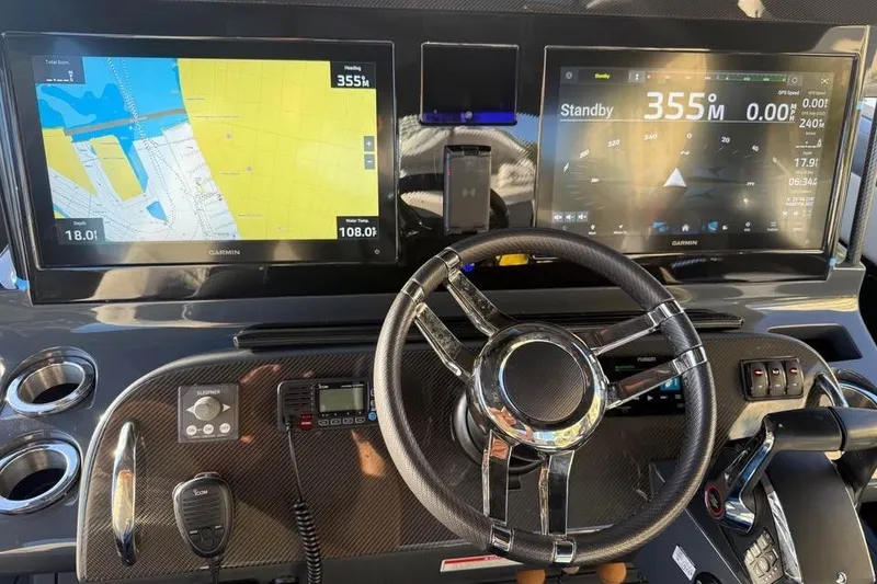 Slide: The Image of Dashboard of 2025 Mystic Powerboats M4200 with dual Garmin displays and steering wheel. - 7