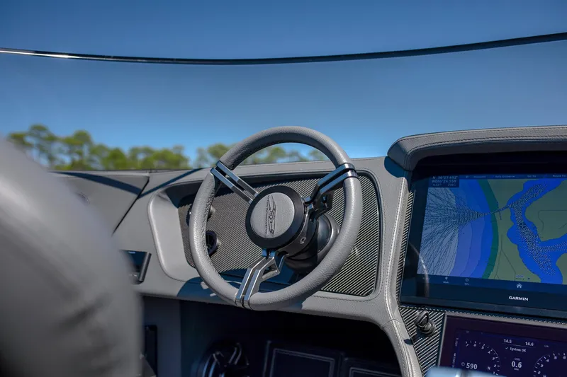 Slide: The Image of 2024 MTI 390X boat dashboard with steering wheel and navigation display. - 13