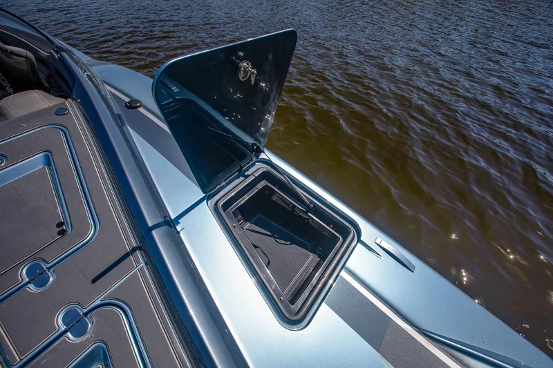 Slide: The Image of 2024 MTI 390X boat with open storage compartment on a sunny day. - 23