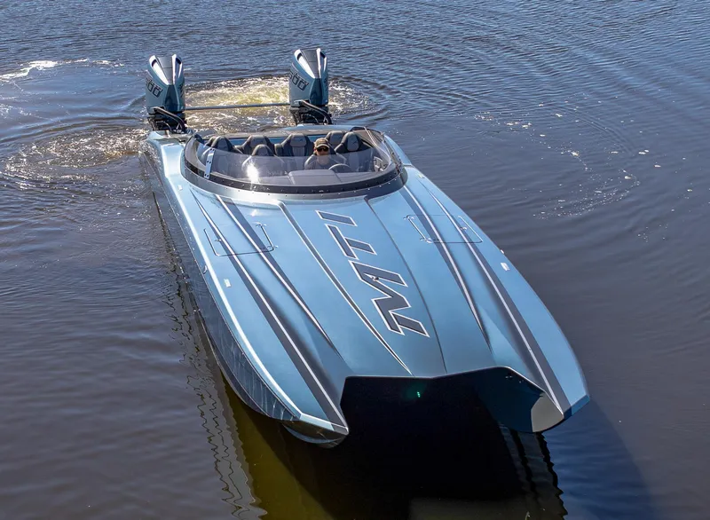 Slide: The Image of 2024 MTI 390X powerboat on water, sleek design, dual engines, metallic finish. - 5