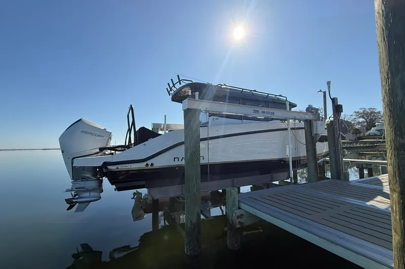 Slide: The Image of 2025 Navan C30 boat docked under clear blue sky, featuring Mercury engine. - 2