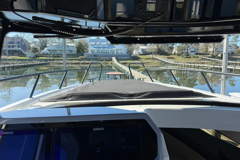 Slide: The Image of 2025 Navan C30 boat docked at a serene waterfront with houses in the background. - 28