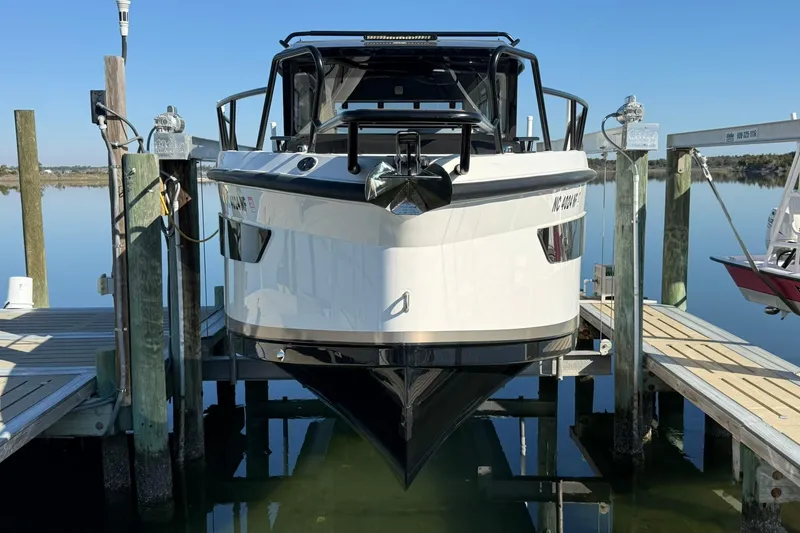 Slide: The Image of 2025 Navan C30 boat docked, reflecting on calm water under clear blue sky. - 4