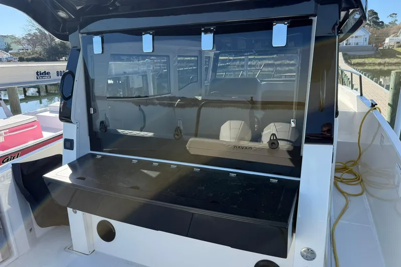 Slide: The Image of 2025 Navan C30 boat interior with seating and storage, docked near a marina. - 7
