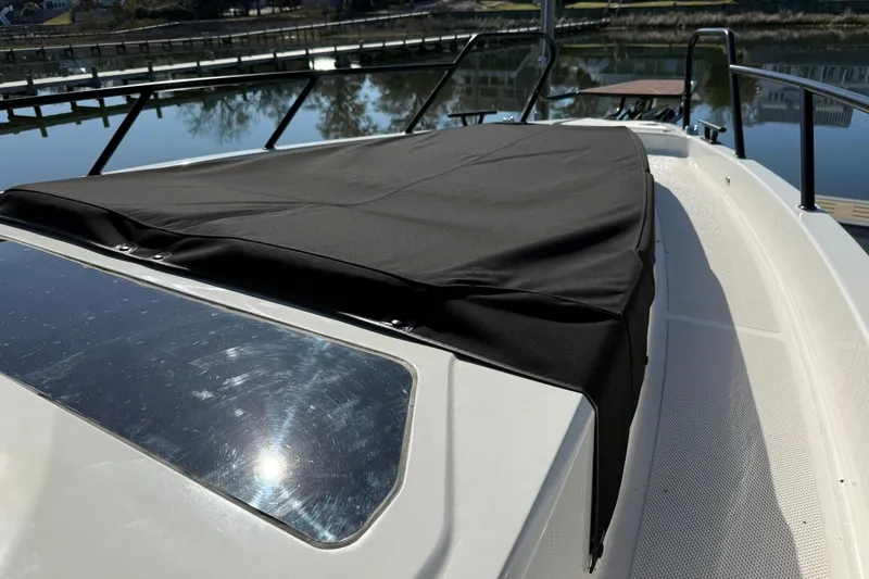 Slide: The Image of 2025 Navan C30 boat with black cover on deck, docked by calm waters. - 9