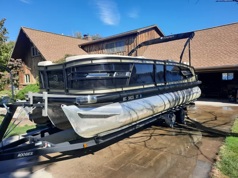 The Image of 2022 Godfrey 23ft Tritoon boat on trailer in front of house. - 0
