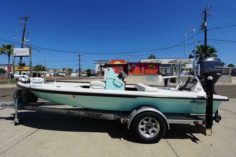 Slide: The Image of 2014 Maverick 17 HPX Tunnel boat on trailer, parked in urban setting under clear blue sky. - 1