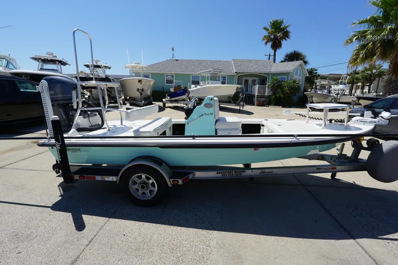 Slide: The Image of 2014 Maverick 17 HPX Tunnel boat on trailer, parked outdoors under clear blue sky. - 4