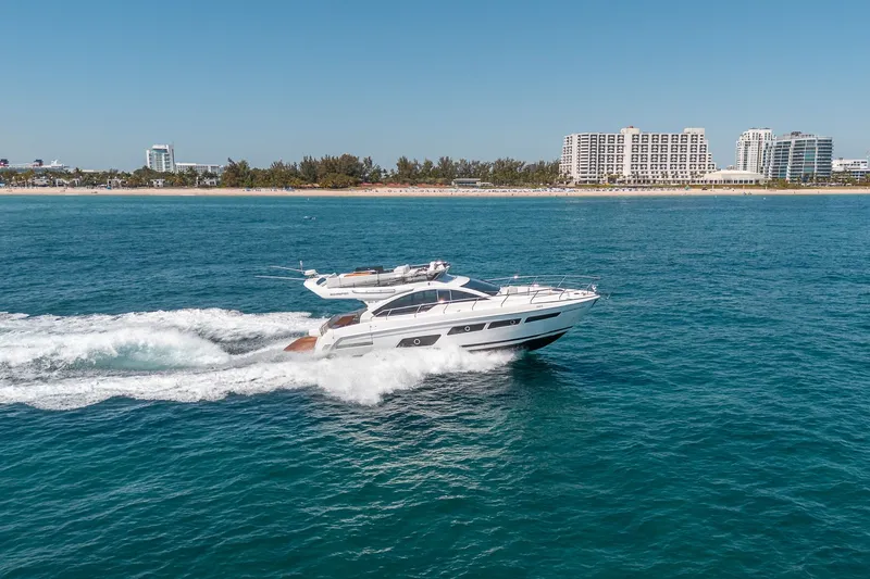 Slide: The Image of Schaefer 510 GT Yacht 2023 cruising on open sea near coastal city. - 19
