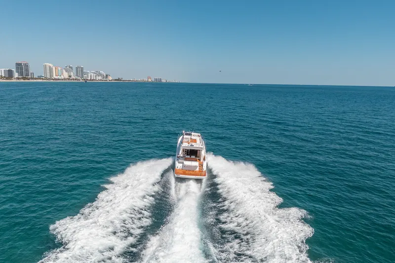 Slide: The Image of Schaefer 510 GT Yacht 2023 cruising on open sea near coastal city. - 21