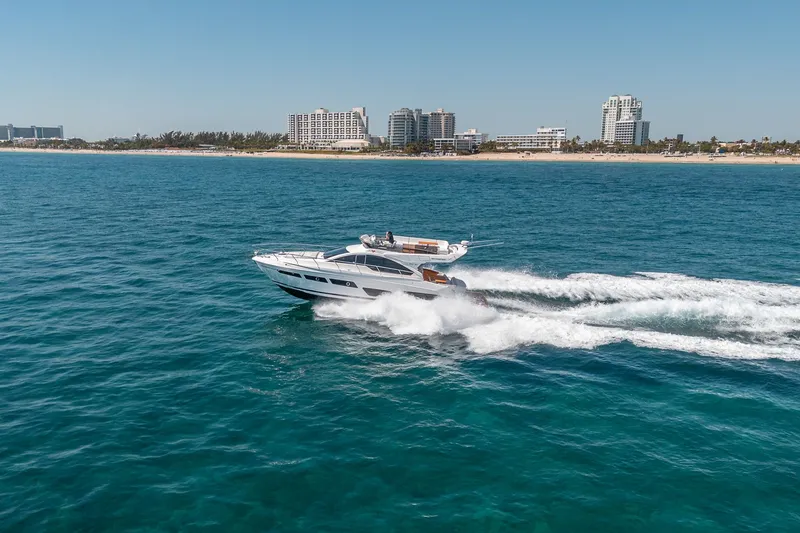 Slide: The Image of Schaefer 510 GT yacht 2023 cruising on open sea near coastal city. - 22