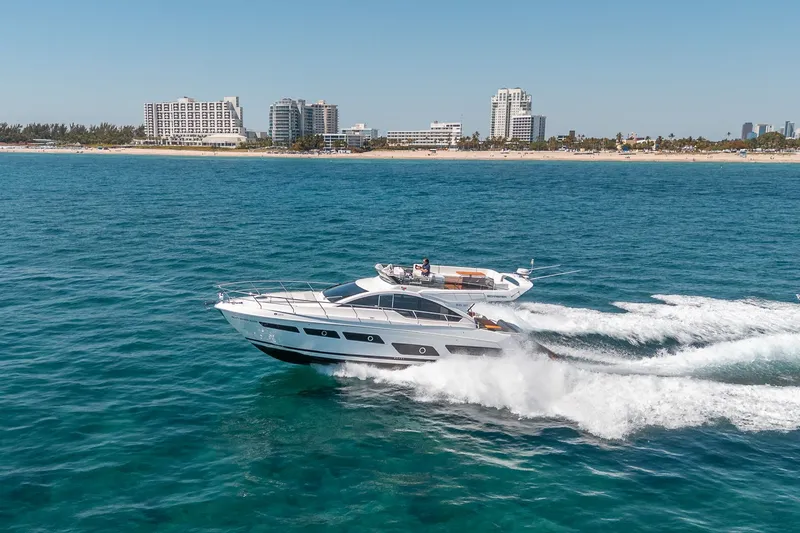Slide: The Image of Schaefer 510 GT Yacht 2023 cruising near coastal city. - 23