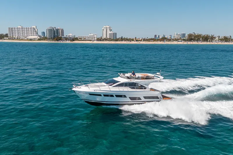 Slide: The Image of Schaefer 510 GT Yacht 2023 cruising on open sea near coastal city. - 24