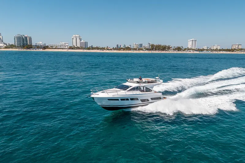 Slide: The Image of Schaefer 510 GT Yacht 2023 cruising on the sea near a city. - 25