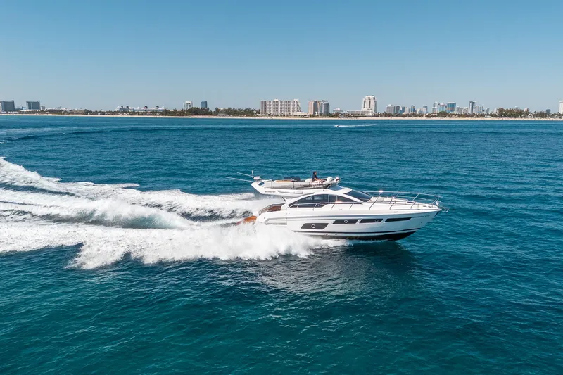 Slide: The Image of Luxury yacht Schaefer 510 GT 2023 cruising on open sea near city skyline. - 31