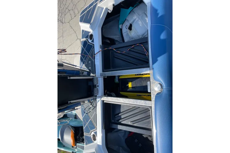 Slide: The Image of 2022 Centurion Ri230 boat interior storage compartments with visible wiring and equipment. - 10