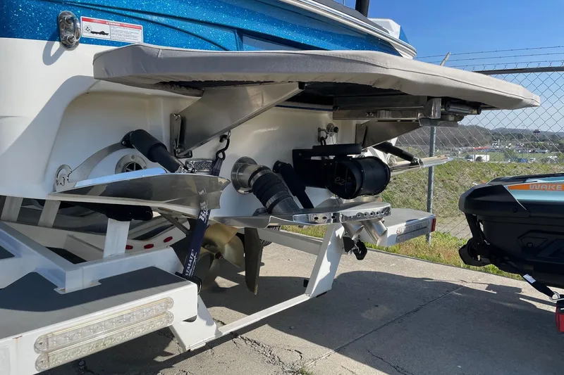 Slide: The Image of 2022 Centurion Ri230 boat rear view with wakeboard equipment and blue exterior. - 11