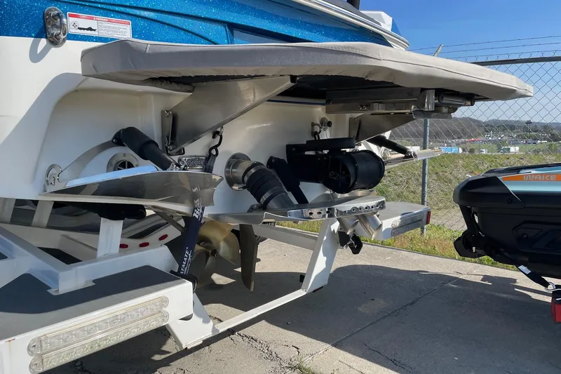 Slide: The Image of 2022 Centurion Ri230 boat rear view with wakeboard equipment and trailer. - 12